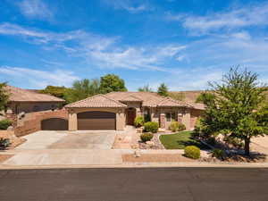 Mediterranean / spanish home featuring an attached garage, driveway, stucco siding, a tiled roof, and a gate