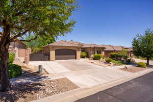 Mediterranean / spanish home with a gate, a garage, concrete driveway, stucco siding, and a tile roof