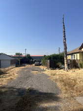 View of yard featuring a detached carport and driveway