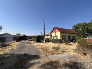 View of property exterior with driveway, a carport, and a garage