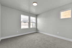 Empty room featuring carpet flooring and a textured ceiling