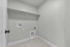 Washroom featuring electric dryer hookup, washer hookup, and light tile patterned floors