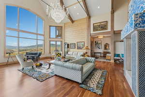Living area featuring wood finished floors, high vaulted ceiling, a chandelier, and a mountain view