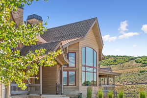 View of property exterior featuring roof with shingles and a chimney