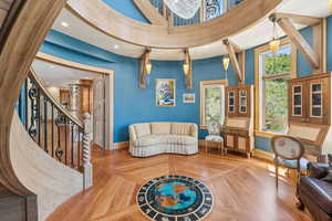 Living area featuring wood finished floors, recessed lighting, a high ceiling, and stairway