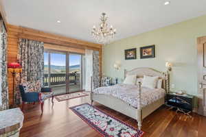 Bedroom featuring access to exterior, a mountain view, wood finished floors, a chandelier, and recessed lighting