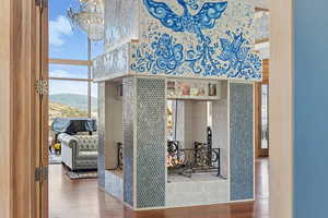 Bathroom with wood finished floors, plenty of natural light, a chandelier, and a fireplace