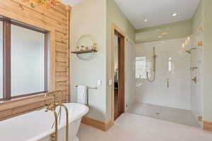 Full bathroom featuring a freestanding tub, a shower stall, and tile patterned floors