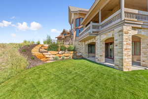 View of green lawn featuring a balcony