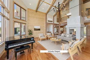Living area with wooden walls, light wood-type flooring, a multi sided fireplace, and recessed lighting