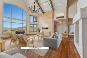 Living room featuring a mountain view, wood finished floors, lofted ceiling, and hanging lights
