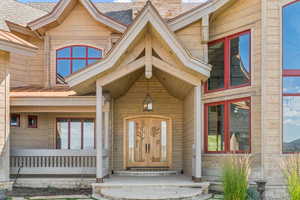 Doorway to property with a chimney and a porch