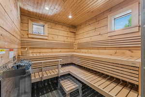 Sauna featuring recessed lighting, wood walls, and wooden ceiling