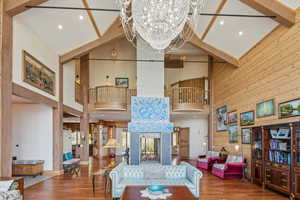 Living area featuring beam ceiling, wood finished floors, wood walls, recessed lighting, and a multi sided fireplace