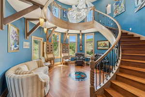 Foyer with a chandelier, stairs, a high ceiling, and parquet flooring