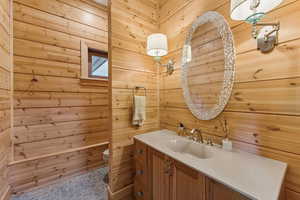 Bathroom with vanity and wood walls