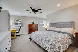 Carpeted bedroom featuring an office area, ceiling fan, and recessed lighting