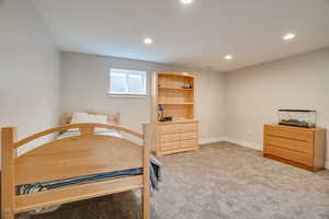 Carpeted bedroom featuring recessed lighting and a desk