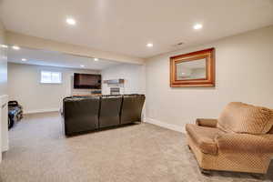 Living area with recessed lighting and light colored carpet