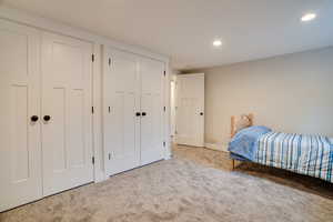 Carpeted bedroom featuring two closets and recessed lighting