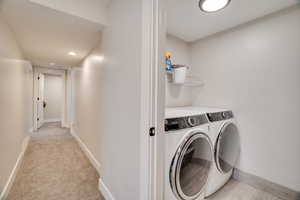 Laundry area featuring washing machine and clothes dryer, recessed lighting, and light colored carpet