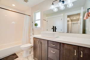 Full bath featuring vanity, shower / bath combo with shower curtain, and recessed lighting