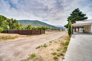 View of dirt / gravel driveway with a mountain view and a view of rural / pastoral area