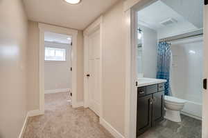 Hallway featuring light carpet and baseboards