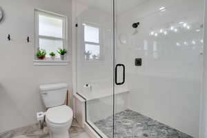 Full bath with a shower stall and marble finish floors