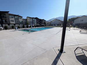 Community pool with a residential view, a patio, and a mountain view