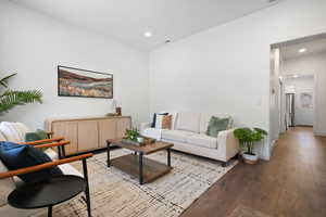 Living room with light wood-style flooring and recessed lighting