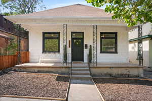 View of front facade featuring covered porch and a shingled roof