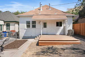 Rear view of house with a fenced backyard, a shingled roof, and a wooden deck