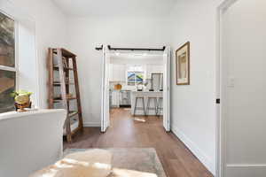 Office, bedroom, or dining room Hall with wood finished floors and baseboards