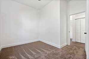 Empty room featuring carpet flooring and baseboards