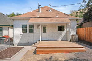 View of front of home featuring roof with shingles and a wooden deck
