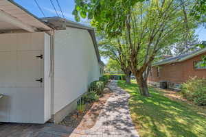 View of side of home featuring a lawn and brick siding