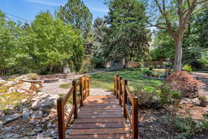 View of yard with an outdoor fire pit, an outbuilding, a patio, and view of wooded area