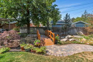 View of yard with a wooden deck and a patio