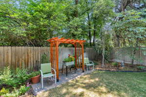 Fenced backyard with a pergola and a patio