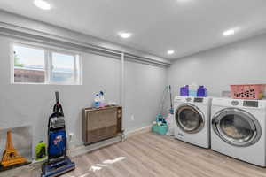 Laundry area with wood finished floors, separate washer and dryer, and recessed lighting