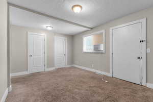 Unfurnished bedroom with carpet flooring and a textured ceiling