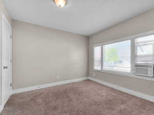 Empty room with carpet floors and a textured ceiling