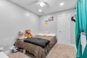 Carpeted bedroom featuring a ceiling fan and recessed lighting