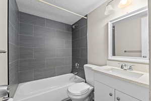 Full bathroom featuring vanity, a textured ceiling, and shower / bath combination