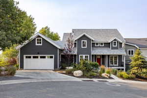 View of front facade featuring driveway, a porch, a garage, and a shingled roof