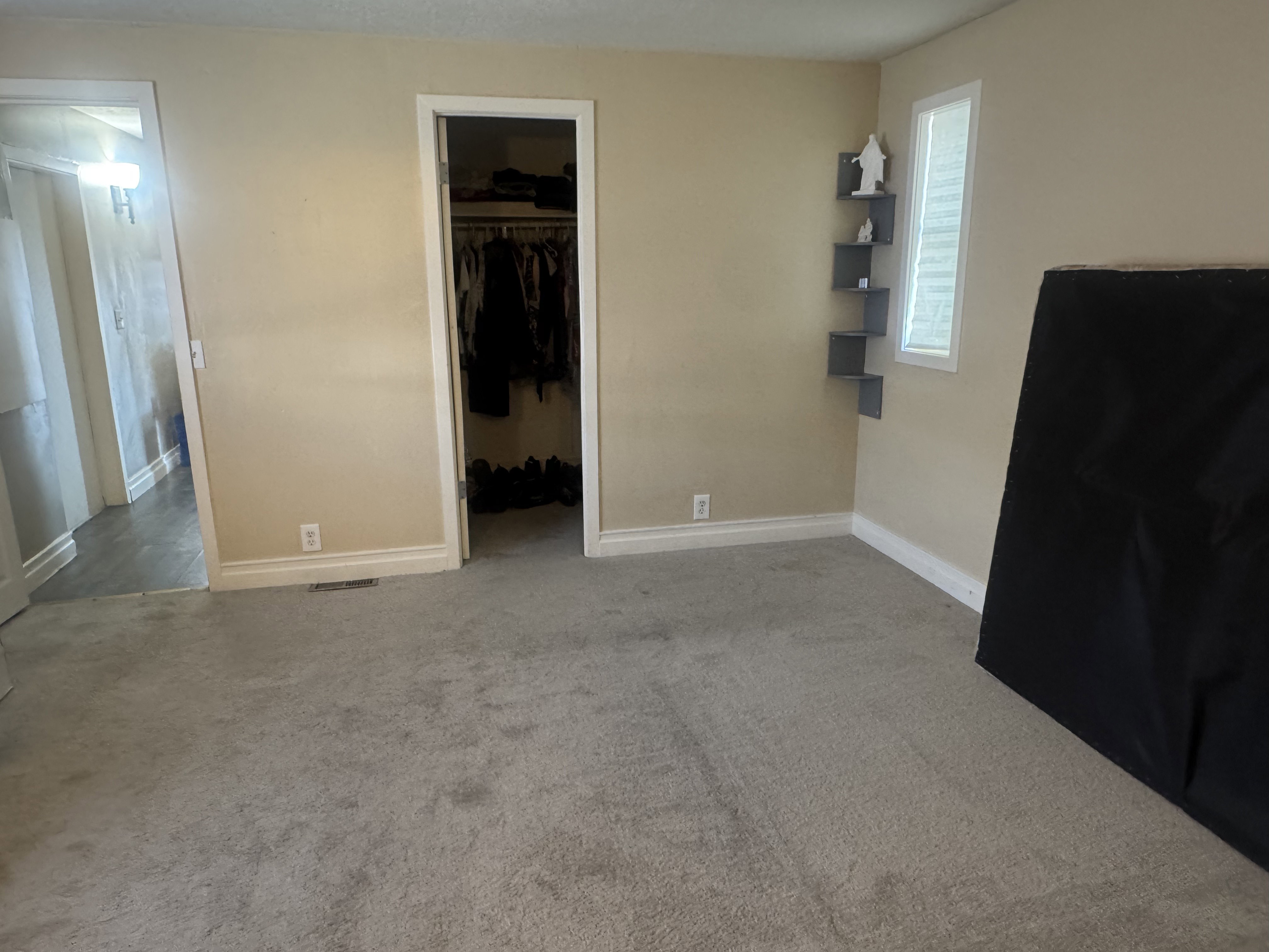 Unfurnished bedroom with carpet flooring and a walk in closet