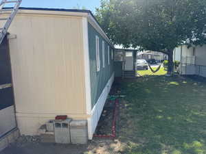 View of side of home featuring entry steps and a lawn
