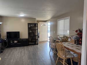 Dining area with a textured ceiling and wood finished floors