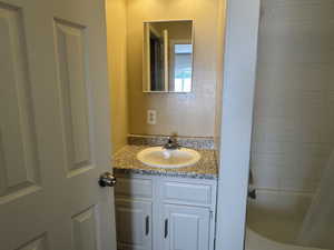 Bathroom with vanity and shower / bath combination with curtain